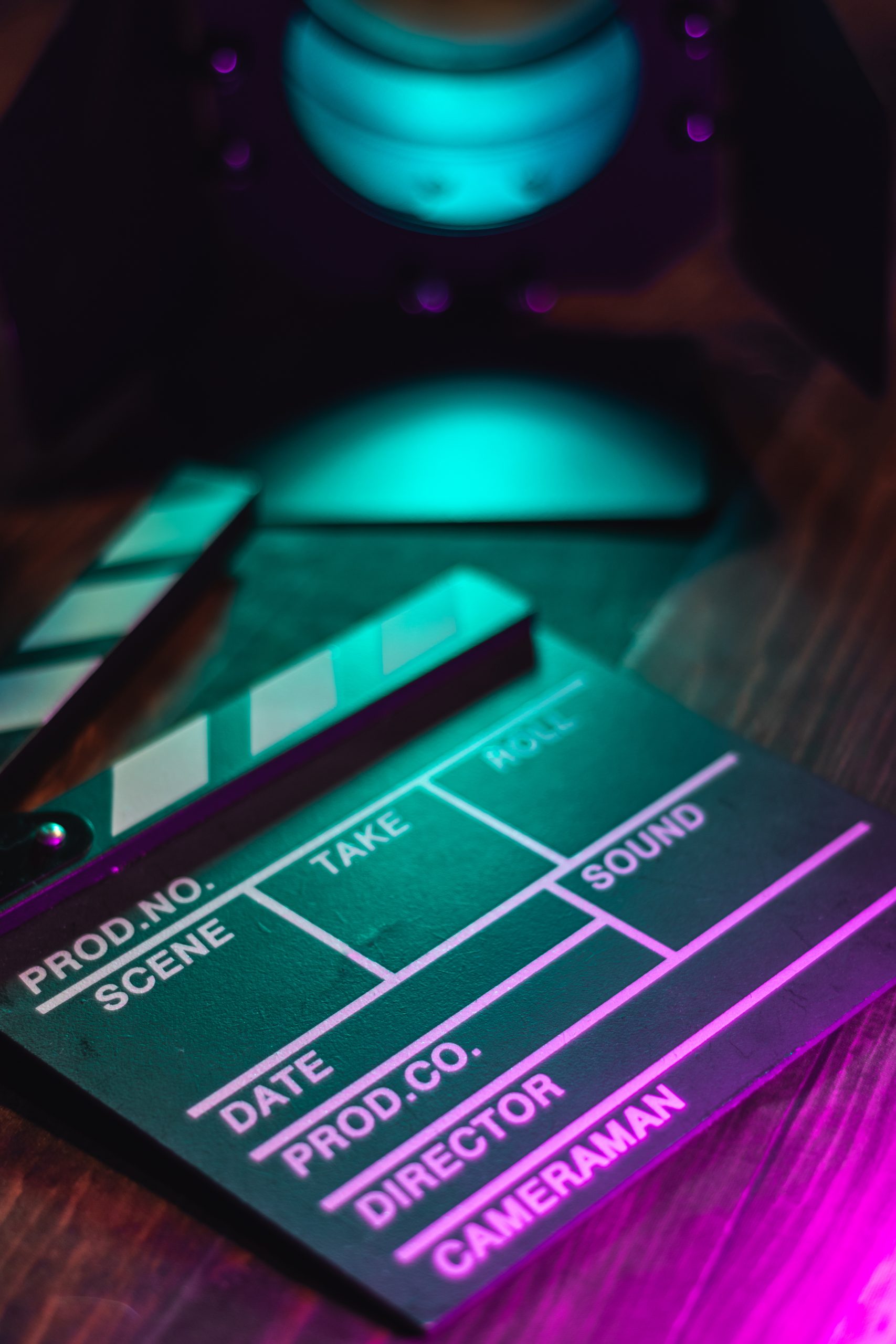 clapperboard laying on a table with blue and purple lighting